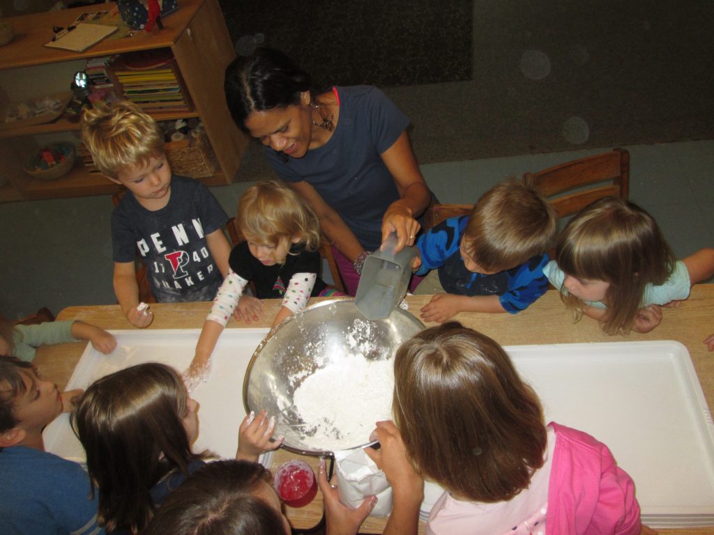Following the recipe for making Ooblek. 1. Gather materials: 1 cup of water; 1 to 2 cups of cornstarch; mixing bowl; water color. "If you don't add water it'll be too dry." "That's called a measuring cup." Preparation: Pour 1 cup of cornstarch into the mixing bowl, and dip your hands into it. Now pour the water in, slowly. Add a few drops of watercolor. 